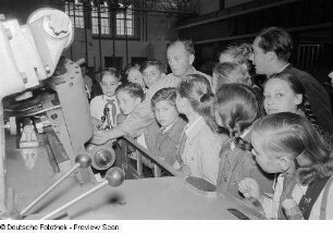 Kinder zu Besuch auf der Leipziger Herbstmesse 1954 vor einer Maschine