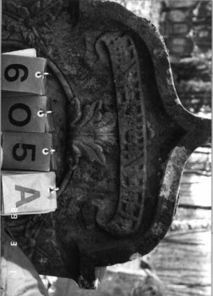 Grabstein 605 (Index: 99753117) Material: Sandstein Zustand: verwittert Maße HxBxT: 109x65x11 cm Beschreibung: Stele, eingezog. Kielbogenabschl. , Schrift eingetieft mit eingezog. Rundbogenabschl. Symbolik: Blätter, Schriftband: Grabstein 605A