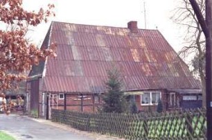 Sehmsdorf: Hofkamp 8: traufständige Fachwerkkate mit Blechdach: Straßenfront mit Eingangstür, rechts Wohntrakt mit Abseite: links Wirtschaftstrakt, Giebelseite mit Scheunentor: vorne Weg, Vorgarten, Jägerzaun