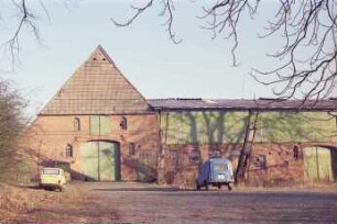 Alte Dorfstraße 22: Bauernhaus: Giebelseite Wirtschaftstrakt mit Scheunentor, darüber Luke: rechts Querbau Wirtschaftsgebäude mit Scheunentor, Obergeschoss mit Verbretterung: davor Hof