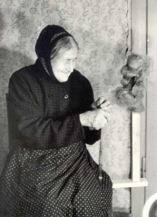 Frau beim Spinnen in Sprey : Handwerkstechniken - Spinnerei. Ort: Sprjowje / Sprey. Frau Hercowa spinnt mit einer Spindel.
