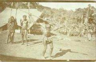 Mit einem Speer bewaffneter Mann der Bomanjoko führt einen Speerstoß vor