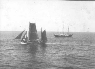 Zweimast-Segelboot läuft längsseits in geringer Entfernung vorbei. Im Mittelgrund Dreimast-Segelboot (ohne Segel). Blick von Bord
