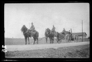 Wirballen (?) (=Virbalis, Litauen): Vierergespann mit Feldküche und 4 Soldaten mit Pickelhaube auf einer Landstraße, im Hintergrund ein landwirtschaftliches Gebäude ("Feldküche mit Bespannung")