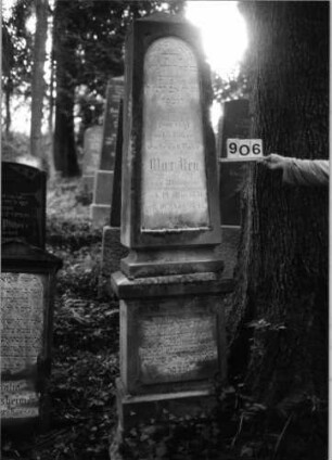 Grabstein 906 (Index: 99802552) Material: Sandstein mit Marmorplatte Zustand: gut Maße HxBxT: 220x43x28 cm Beschreibung: erhöht. mehrfach getreppt. Sockel, Obelisk, Inschriftenplatte mit Rundbogenabschluß Besonderheit: Endreim: Grabstein 906