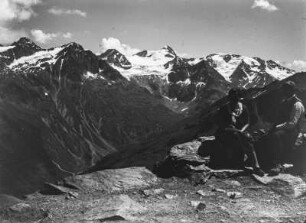Personen im Gebirge : Zwei Personen sitzen am Rande des Hinteren Brunnenkogels, dahinter der Stubaier Gletscher.