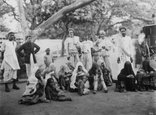 Kalkutta (Westbengalen), Indien. Gruppenbild mit indischen Frauen, Männern und Kindern auf einer Straße mit Kutsche