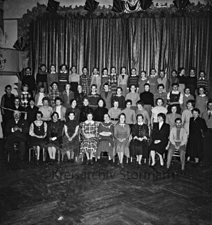 Oldesloer Jugendchor: Hotel Oldesloer Hof: Saal: vor Bühne: Probe für Faschingsveranstaltung: Gruppenaufnahme mit Musikdirektor August König