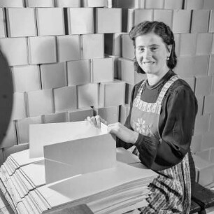 Frau stellt Verpackungen aus Karton her
