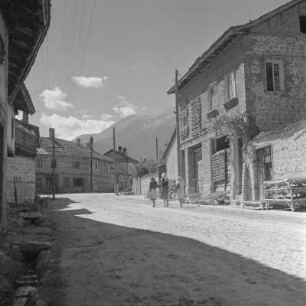 Alltagsbild. Frauen unterwegs in Bansko. Gestelle für das Trocknen der Tabakblätter am Wohnhaus in Bansko