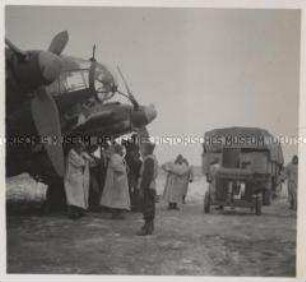 Wehrmachtssoldaten, Flugzeug, Sind auch bei größter Kälte einsatzbereit Heinkel He 111. Die warme Winterkleidung schützt das Bodenpersonal vor der eisigen Kälte und dem pfeifenden Wind auf dem Rollfeld. (Flughafen Schatalowka-Ost)
