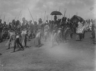 König Msinga mit Gefolge : König Juhi Msinga von Ruanda (mit Schirm) mit seinem Gefolge in festlicher Kleidung