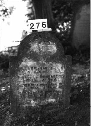 Grabstein 276 (Index: 100085112) Maße HxBxT: 77x56x10 cm Beschreibung: Stele, eingezogener Rundbogenabschluß, Schriftfeld eingetieft: Grabstein 276