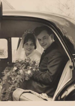 Fotografie eines Brautpaars im Fond eines Autos