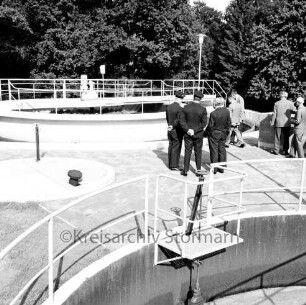 Abwasser: Klärwerk: Wöhrendamm: 3. Bauabschnitt: Einweihung: vorn und hinten zwei Klärbecken: dazwischen und hinten Gäste: hinten Bäume