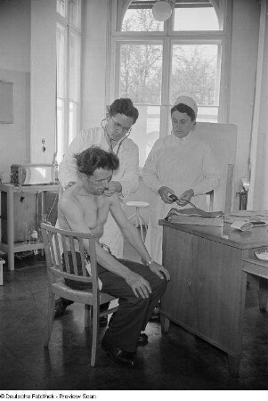 Arzt und Krankenschwester bei der Untersuchung eines Patienten