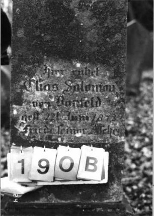Grabstein 190 (Index: 99752053) Material: Sandstein Zustand: leicht verwittert Maße HxBxT: 148x38x27 cm Beschreibung: konische Stele, getreppt. Sockel, giebelart. Abschl. m. Verdach. , Schriftfeld eingetief Symbolik: gestelztes Rundbogenfries: Grabstein 190B
