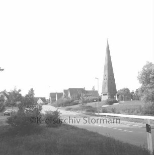 Rethwischdorf: Kirchberg: hinten rechts evangelische Christuskirche: vorn links Grünfläche mit Büschen: dahinter kleine Straße mit Pkw: hinten Wohnhäuser