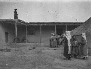 Karawanserei : Eine Gruppe von Zentralasiaten in einem Hof, vermutlich einer Karawanserei im Tian Shan Hochgebirge