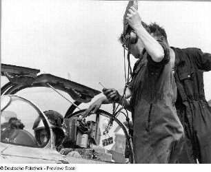 Rothenburg (Oberlausitz). Nationale Volksarmee - Luftstreitkräfte. Militärflugplatz für Jagdflieger-Ausbildung. Techniker auf der Leiter am Flugzeugrumpf und Pilot in der Kabine