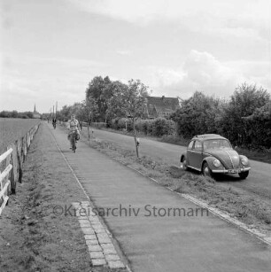 Straßen: Radweg Fahrradfahrern am Autobahnzubringer zur A 1: rechts VW-Käfer: Blick auf Siek im Hintergrund