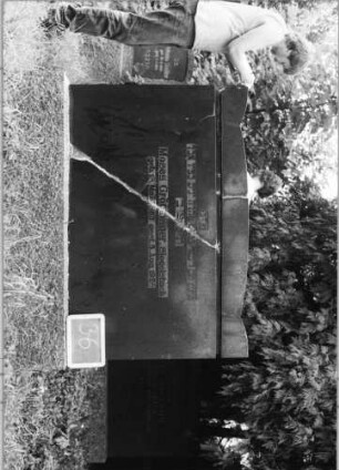 Grabstein 36 (Index: 99753482) Material: Granit Zustand: gebrochen und repariert Maße HxBxT: 125x133x15 cm Beschreibung: Stele breit, Sockel, Korbbogenabschluß mit Eckakroteren Besonderheit: kulturhistorisch wertvoll / hist.-wiss. Gründe (Gemeindestellun): Grabstein 36