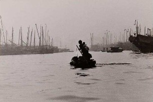 Mutter mit Kind, ein kleines Boot im Hafen steuernd, Hongkong