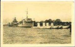 Kriegsschiffe und U-Boote an einem Kai