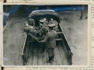 Foto eines zum Transport von Verwundeten eingerichteten Lastkraftwagens, der gerade beladen wird