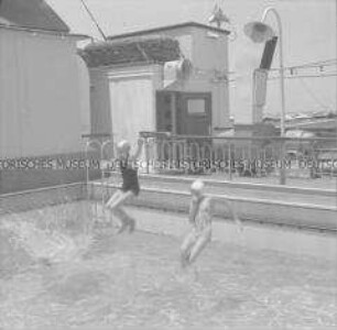 Drei Damen beim Sprung ins Schwimmbecken des Hochseepassagierdampfers "Columbus"