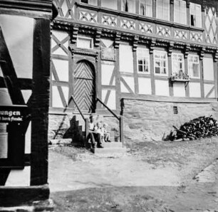 Fachwerkhaus : Mann mit zwei Kindern auf der Treppe eines Fachwerkhauses