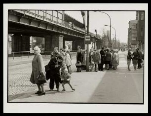 Straßenszene mit Wartenden an der Haltestelle, Schönhauser Allee, Prenzlauer Berg, Berlin