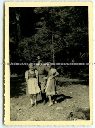 Wehrmachtsoffizier mit zwei Frauen im Wald