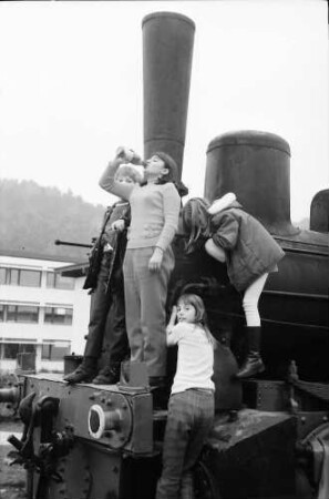 Stegen: Alte Lokomotive im Hof mit Kindern, von unten