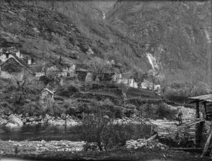 Berghang : Blick auf einen Berghang mit Steinhütten, im Hintergrund ein Wasserfall