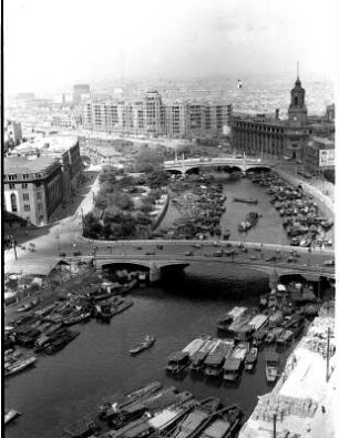 Stadtansicht mit von Brücken überquertem Fluss und einer Vielzahl von Booten