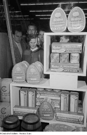 Besucher der Leipziger Herbstmesse 1954 an einem Stand mit polnischen Fleischkonserven