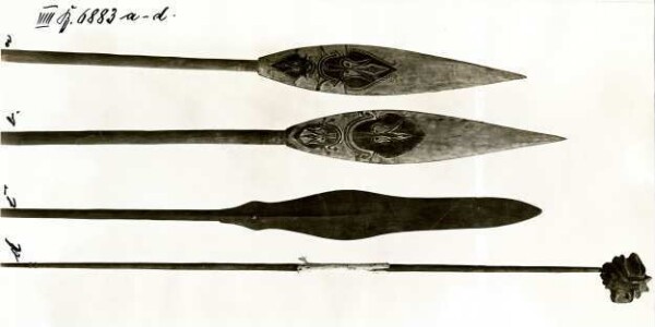 "Three spear-like objects and a clay-clad mask"