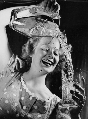 Werbefoto für einen Prospekt der Hamburger Wasserwerke. Das Modell Eva Roscher gießt Wasser aus einer Glaskaraffe in ein Glas.