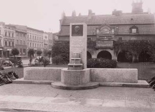 Kreuzburg, Denkmal für Gustav Freytag : Kreuzburg (Kluczbork/Polen), am Ring. Brunnendenmal für Gustav Freytag (1816-1895, Dichter und Schriftsteller), Bronzeplatte, Sandstein, wohl um 1916