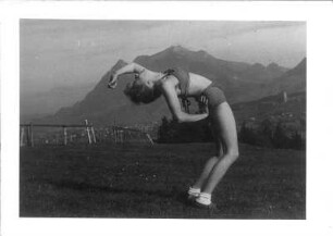 Sonthofen. Frau bei einer gymnastischen Freiluftübung. Blick zum Ort mit Ordensburg und zum Grünten