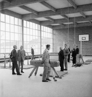 Sporteinrichtungen: Turnhalle: Querweg: Einweihung: Innenansicht: Besichtigung durch Funktionsträger und Gäste: in der Mitte aufgebaute Turngeräte mit Matten