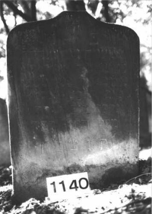 Grabstein 1140 (Index: 99899843) Material: Sandstein Zustand: unten verwittert Beschreibung: Stele mit Schulterbogenabschluss, von der Spitze herabhängende Blüte Symbolik: Blüte Besonderheit: keine Maßangaben: Grabstein 1140