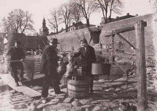 Anlegestelle der Binnenfischerei am Oderufer. Fischer beim Anlanden und Wägen ihres Fanges (mit einfacher Hebelwaage, an einem Holzgalgen hängend befestigt)