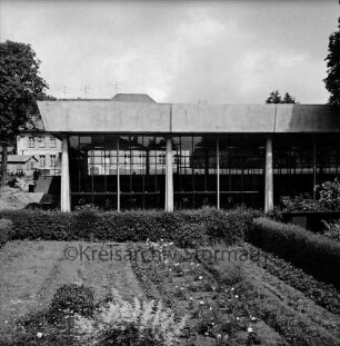 Stormarnhalle Bad Oldesloe: Am Bürgerpark: Blick von Südosten: vorn Garten mit Hecken: hinten links Hütte: dahinter Wohnhaus und Bäume: 20. Juni 1968