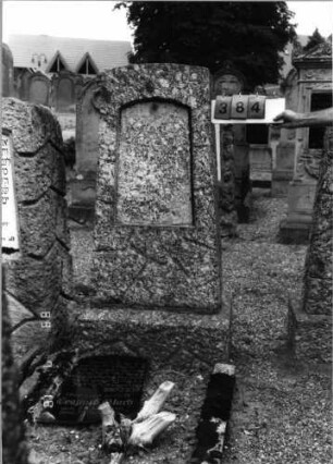 Grabstein 384 (Index: 99797396) Material: Granit, schwarze Glasplatte Zustand: Granit-gut/Platte-stark verwittert Maße HxBxT: 159x56x27 cm Beschreibung: Stele rustiziert, Sockel: Grabstein 384
