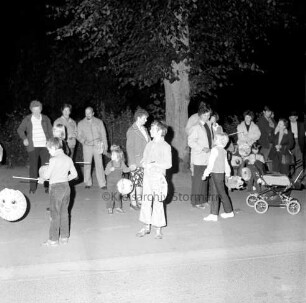 Laternenumzug: Freiwillige Feuerwehr Mönkhagen: vorn Kinder mit Laternen: rechts Kinderwagen: hinten Erwachsene: dahinter Baum Nacht