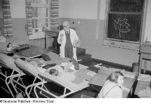 Ein Lehrer sowie mehrere liegende Schüler beim Sachkunde-Unterricht im Dr.-Georg-Sacke-Heim
