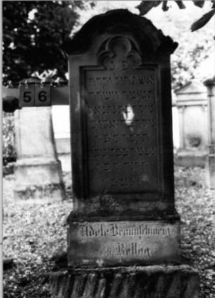 Grabstein 56 (Index: 100086708) Material: Sandstein Zustand: leicht verwittert Maße HxBxT: 154x55x21 cm Beschreibung: Stele, getreppter Sockel, eingezogener Rundbogenabschluß mit Verdachung, eingetieftes Schriftfeld mit Maßwerk: Grabstein 56