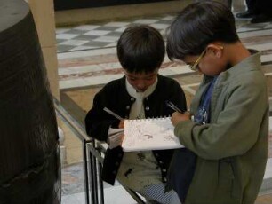 Museum Louvre, zwei kleinen Jungen skizzieren in der persischen Skulturenabteilung Exponate